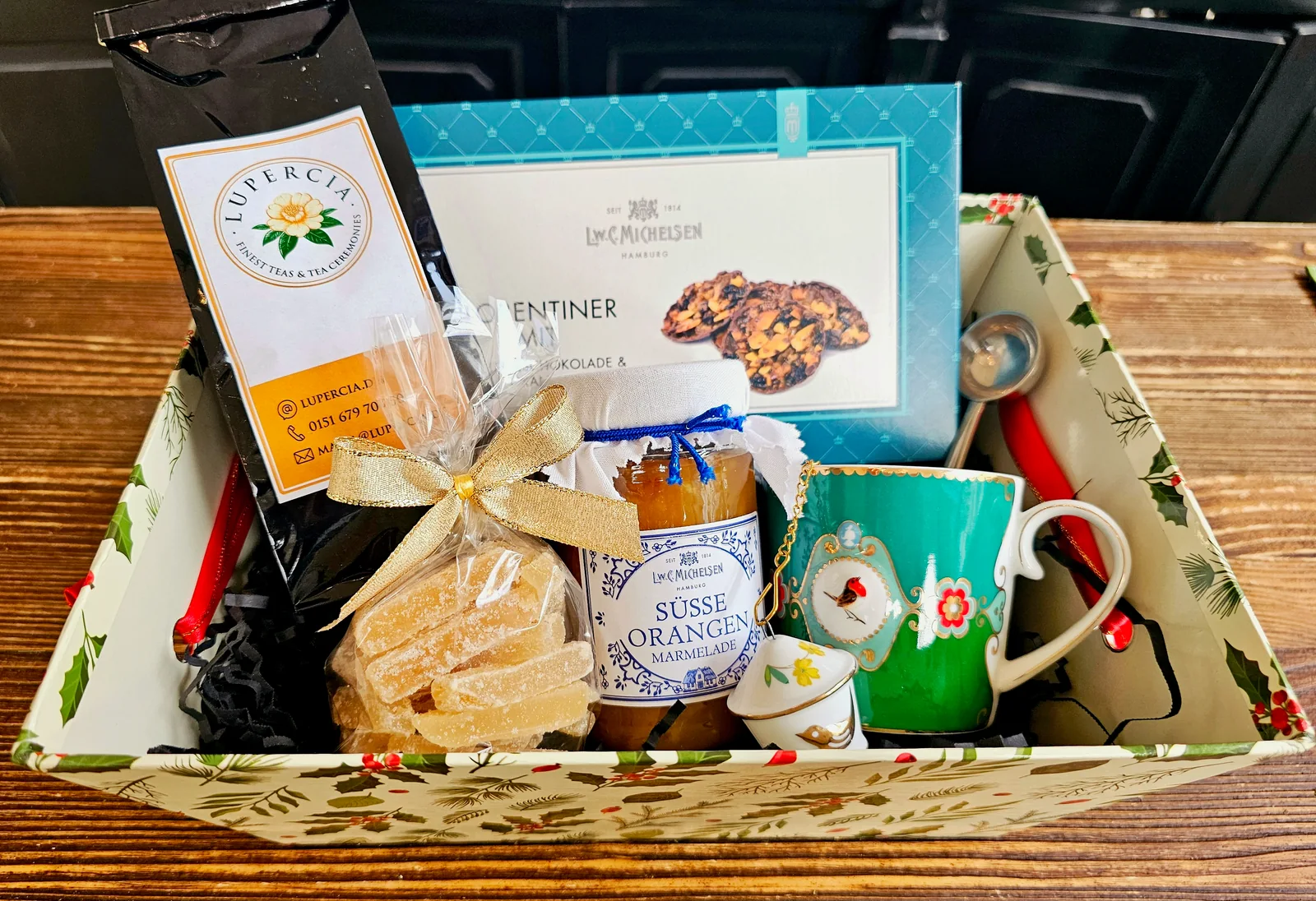 Eine Geschenkbox mit Lupercia Tee, türkisfarbener Porzellantasse, Florentinern, Ingwer und Orangenmarmelade